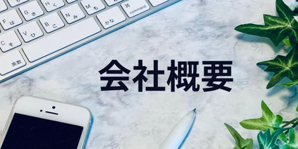 ノートパソコンのキーボードとスマートフォンが並ぶデスクに置かれた「会社概要」の文字と観葉植物
