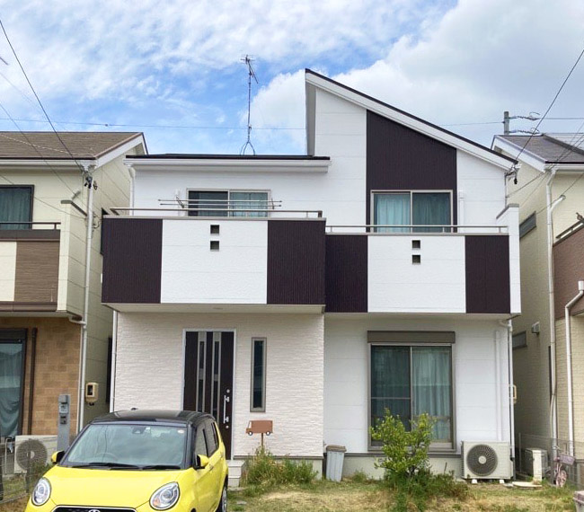 白とブラウンの外壁の戸建て住宅