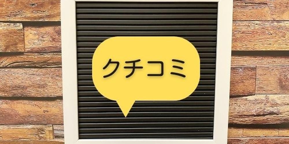 木目の壁を背景にした黒板フレームの中央に、黄色い吹き出しで「クチコミ」と書かれたレビューイメージのビジュアル。