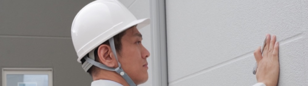 外壁のひび割れを確認する作業員