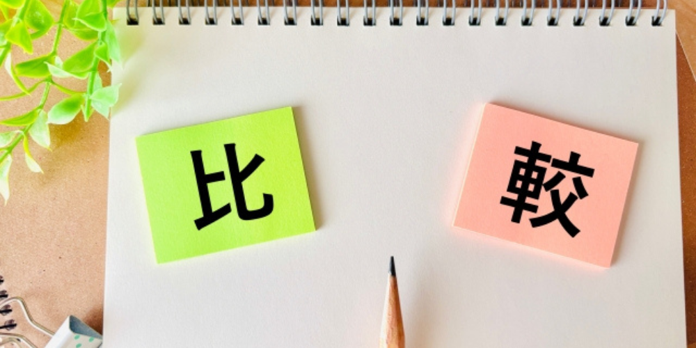 「比較」と書かれた付箋がノートに貼られた画像、中央には鉛筆が置かれている
