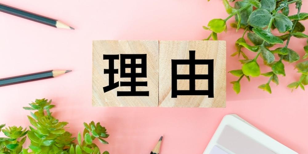 ピンクの背景に観葉植物と「理由」の文字が書かれた木製ブロックが置かれたイメージ画像